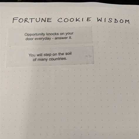 Open notebook page with printed fortune cookie wisdom snippets prompting mindfulness and journaling.
